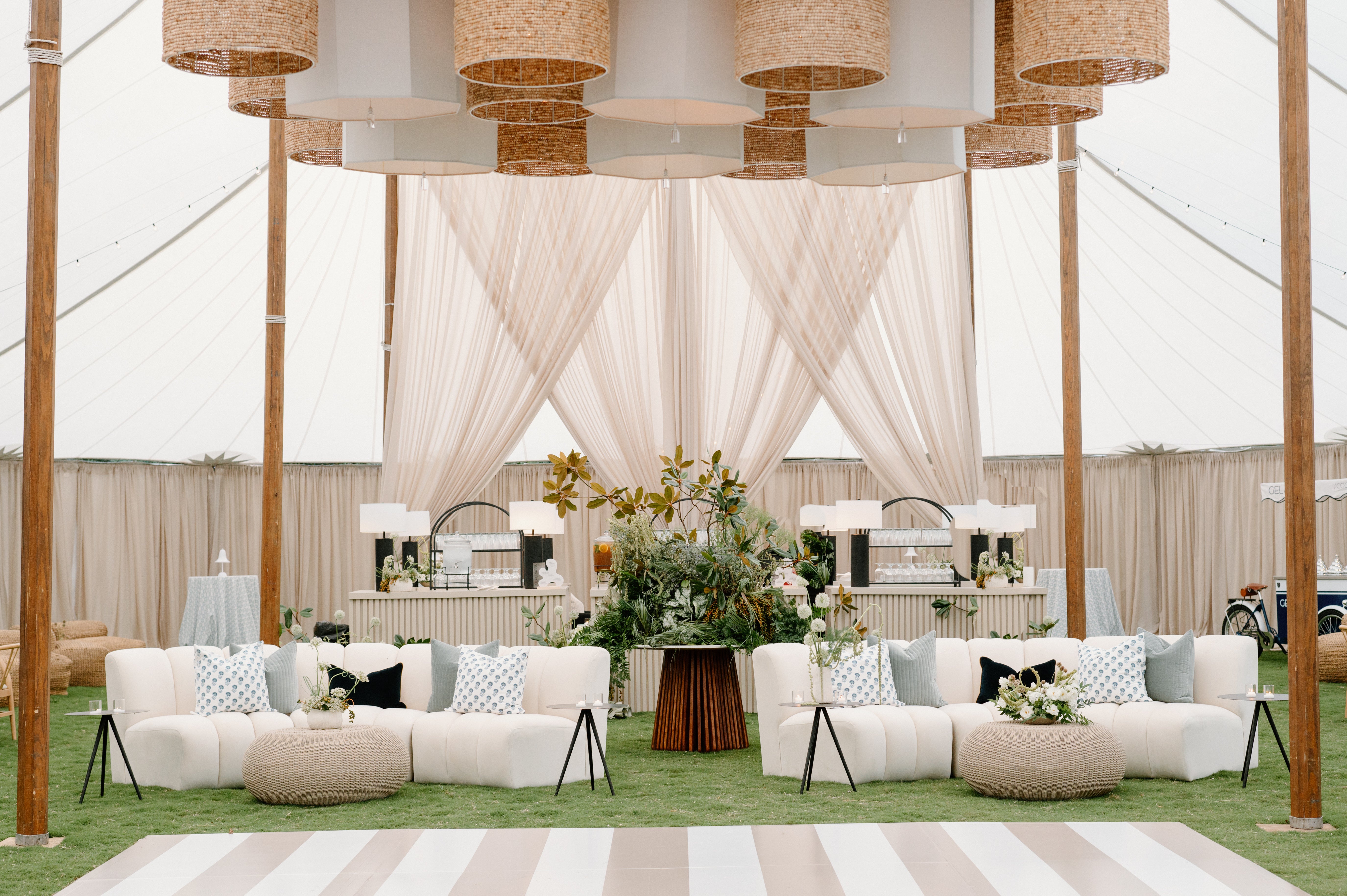 Tented garden wedding reception in Tennessee with overhead greenery and draped lighting