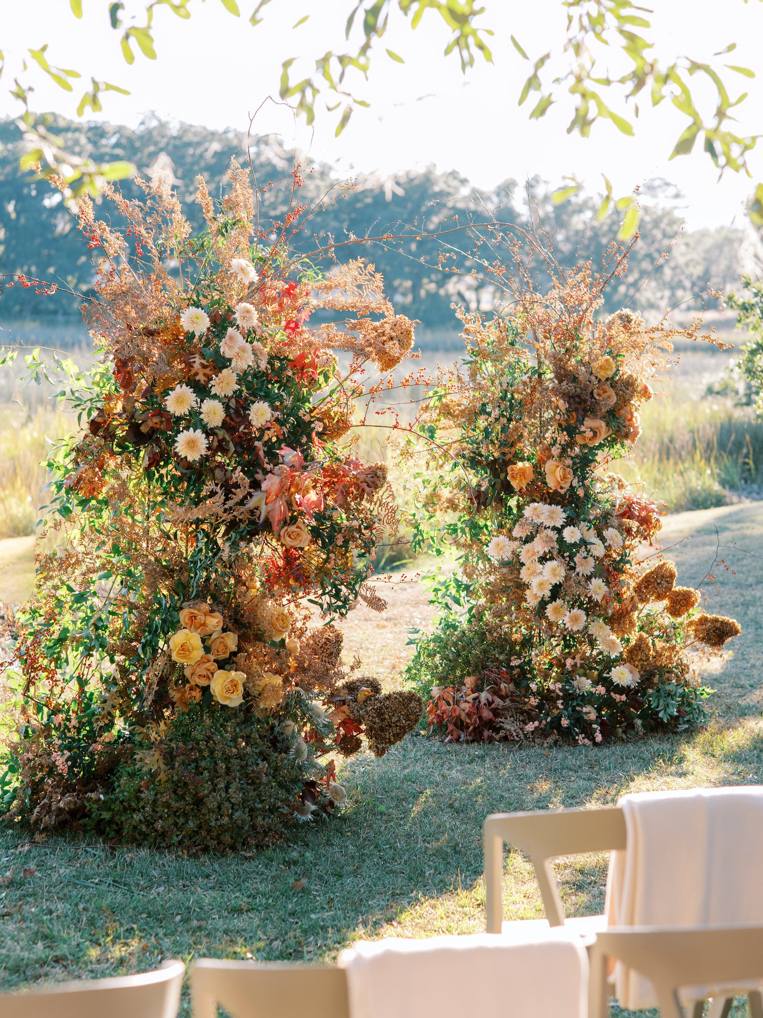 Kiawah River ceremony setup featuring grounded floral installations and soft-toned guest chairs from Mayker Events