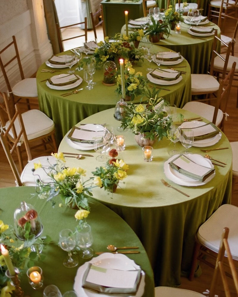 Spring-inspired reception setup by Meredith Tanton Events featuring round tables with green linens, yellow florals, gold flatware, and modern garden-style arrangements.