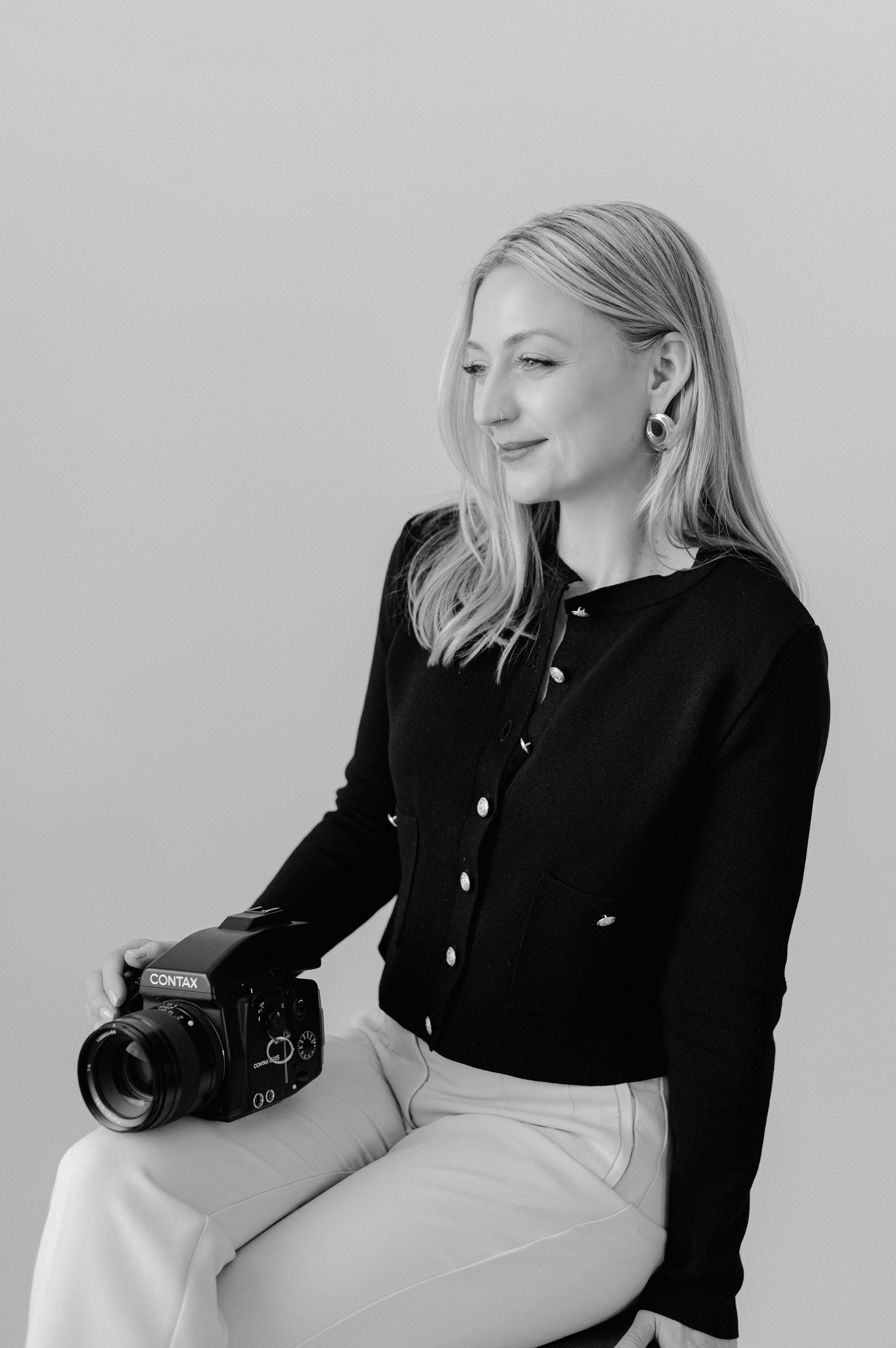 Kéra Golumbisky holding a camera against a plain background